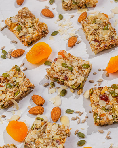 Muesli bars with almonds and apricots on a white surface