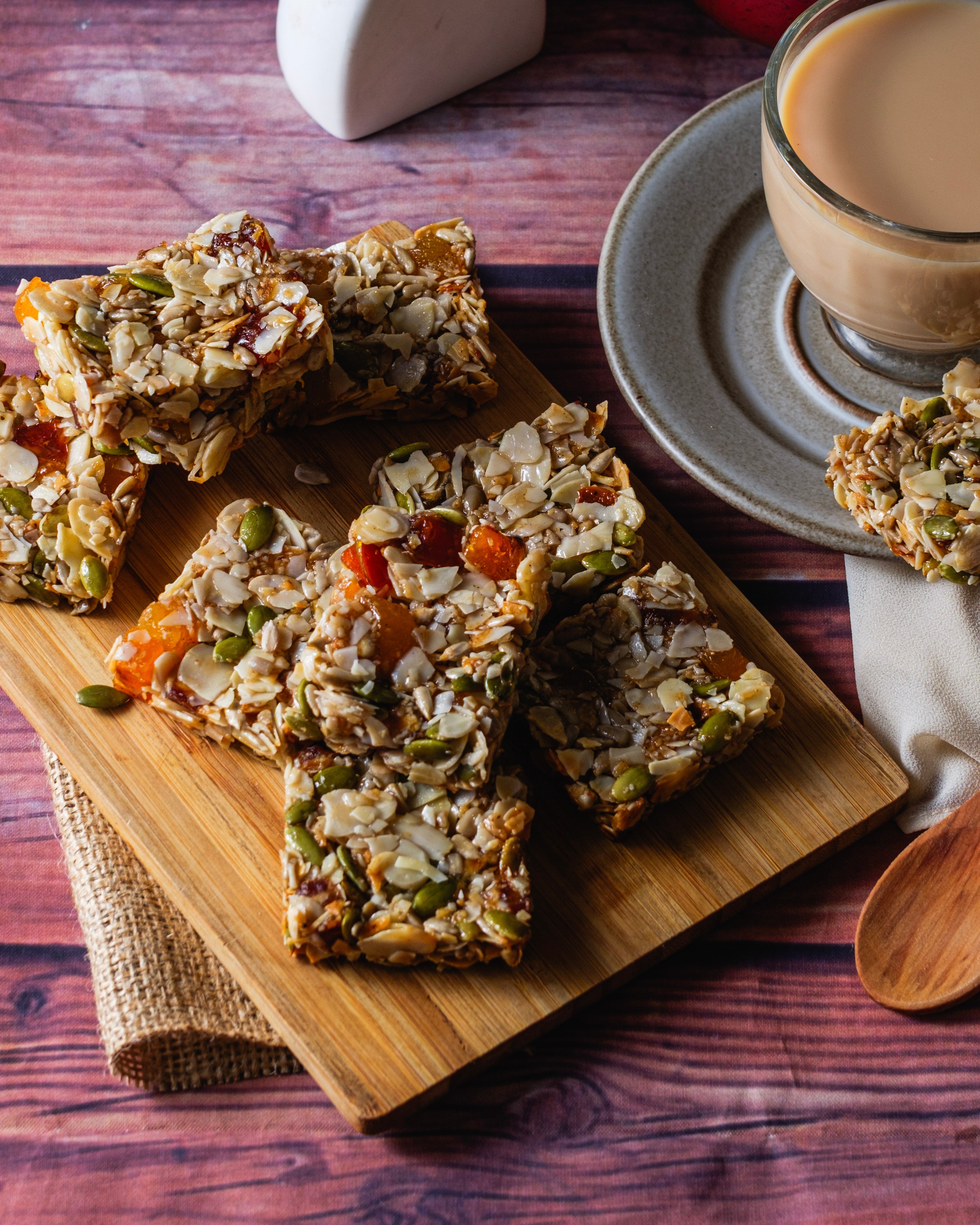 Muesli bars on a wooden board with a glass of milk on a wooden table
